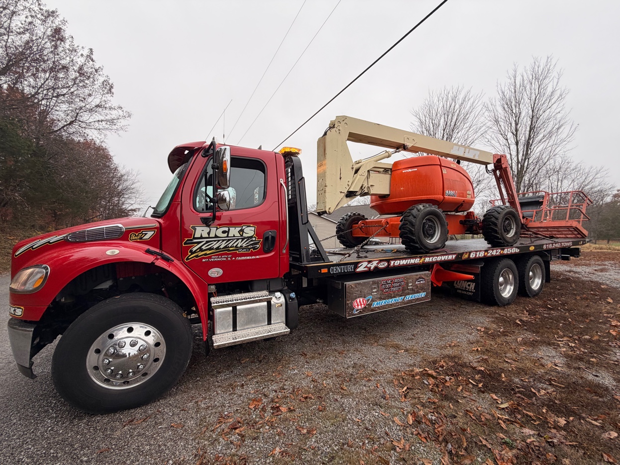 Rick's Towing flatbed hauling boom lift construction equipment